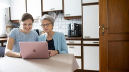 Mutter und Tochter zusammen am Laptop.
