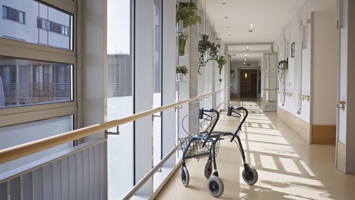 Ein Rollator in einem leeren Korridor.