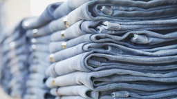 Das Bild zeigt lauter gefaltete Jeans-Hosen.