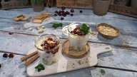 Das Bild zeigt zwei Gläschen mit dem Joghurt-Mandel-Kokos-Dessert.