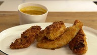 Das Bild zeigt Chicken Nuggets, serviert auf einem weißem Teller.