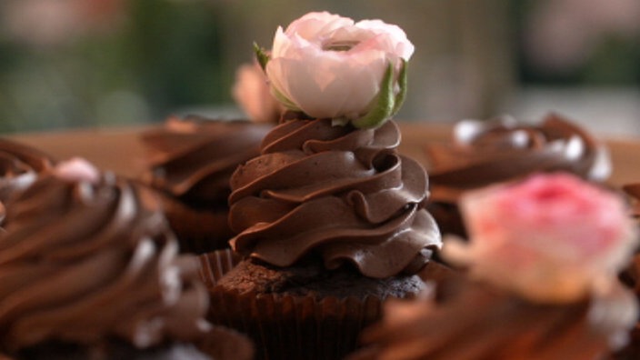 Mehrere Chocolate Heaven Cupcakes, verziert mit Rosen 