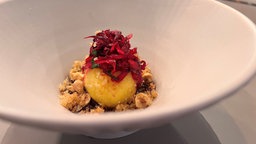 Festtagsknödel auf einem weißen, vertieften Teller mit Rotkohl garniert.
