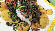 Gebratenes Kabeljaufilet mit Bratkartoffeln auf einem Teller angerichtet