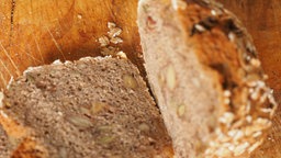 Brotlaib und Brotscheibe auf Brettchen
