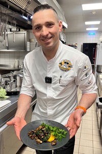 Sternekoch Tobias Schlimbach bereitet Grünkohl-Bratlinge auf Kürbis-Kartoffel-Stampf mit Waldpilzen