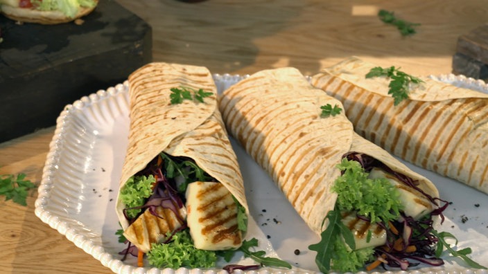 Das Bild zeigt drei angerichtete Halloumi-Wraps.