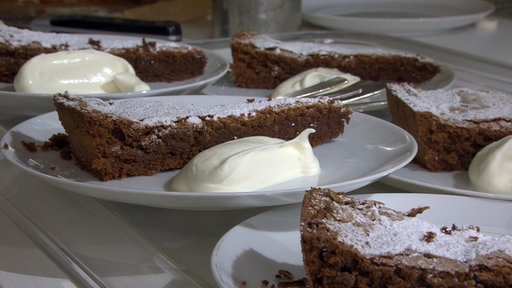 Stücke von Martinas Schokoladenkuchen mit Sahne auf Tellern