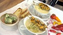 Zwei Suppentassen mit Fenchelcremesuppe, darüber je zwei Muschelspießchen