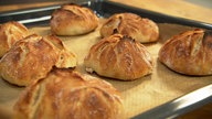 Das Bild zeigt ein Backblech mit den frischen Aufbackbrötchen.