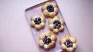 Hefeteilchen in Blütenform mit Blaubeeren auf einem Teller