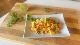 Reis-Gemüse-Salat mit Papaya, Ananas und Mango auf einer Schale