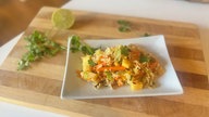 Reis-Gemüse-Salat mit Papaya, Ananas und Mango auf einer Schale