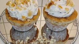 Schokomuffins mit Mandelstückchen auf einem Spiegelteller