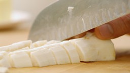 Das Bild zeigt wie eine Pastinake geschnitten wird.