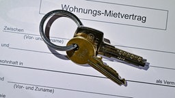 Ein Wohnungsschlüssel liegt auf einem Mietvertrag.