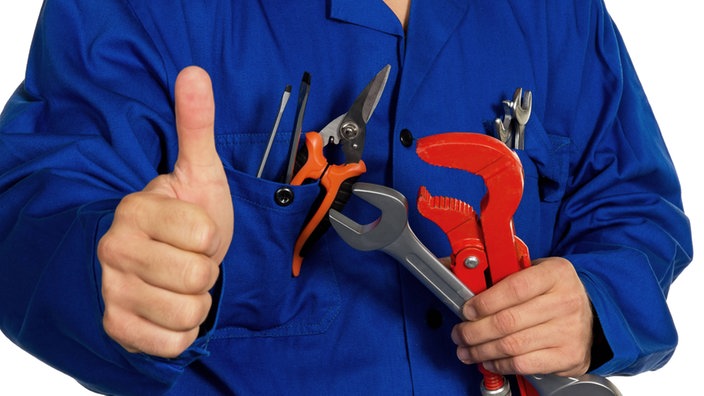 Das Bild zeigt einen Handwerker mit Werkzeug, der mit dem Daumen nach oben zeigt. 