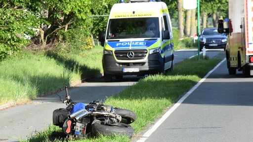 Die Polizei vorort mit der Unfallaufnahme; im Rasen das Motorrad