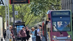 Eine Bahn fährt über eine große Straßenkreuzung in Köln.