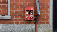 Kaputter Kaugummi-Automat neben einem defekten Rohr