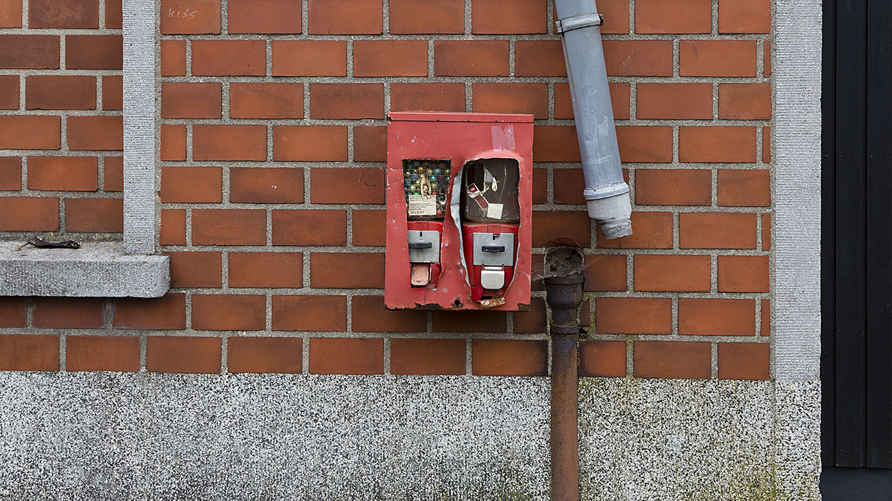 Kaputter Kaugummi-Automat neben einem defekten Rohr