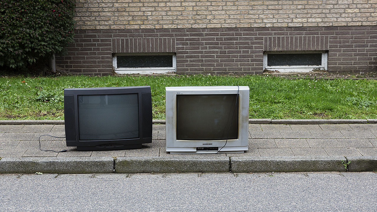 Zwei alte Fernsehgeräte stehen auf der Straße