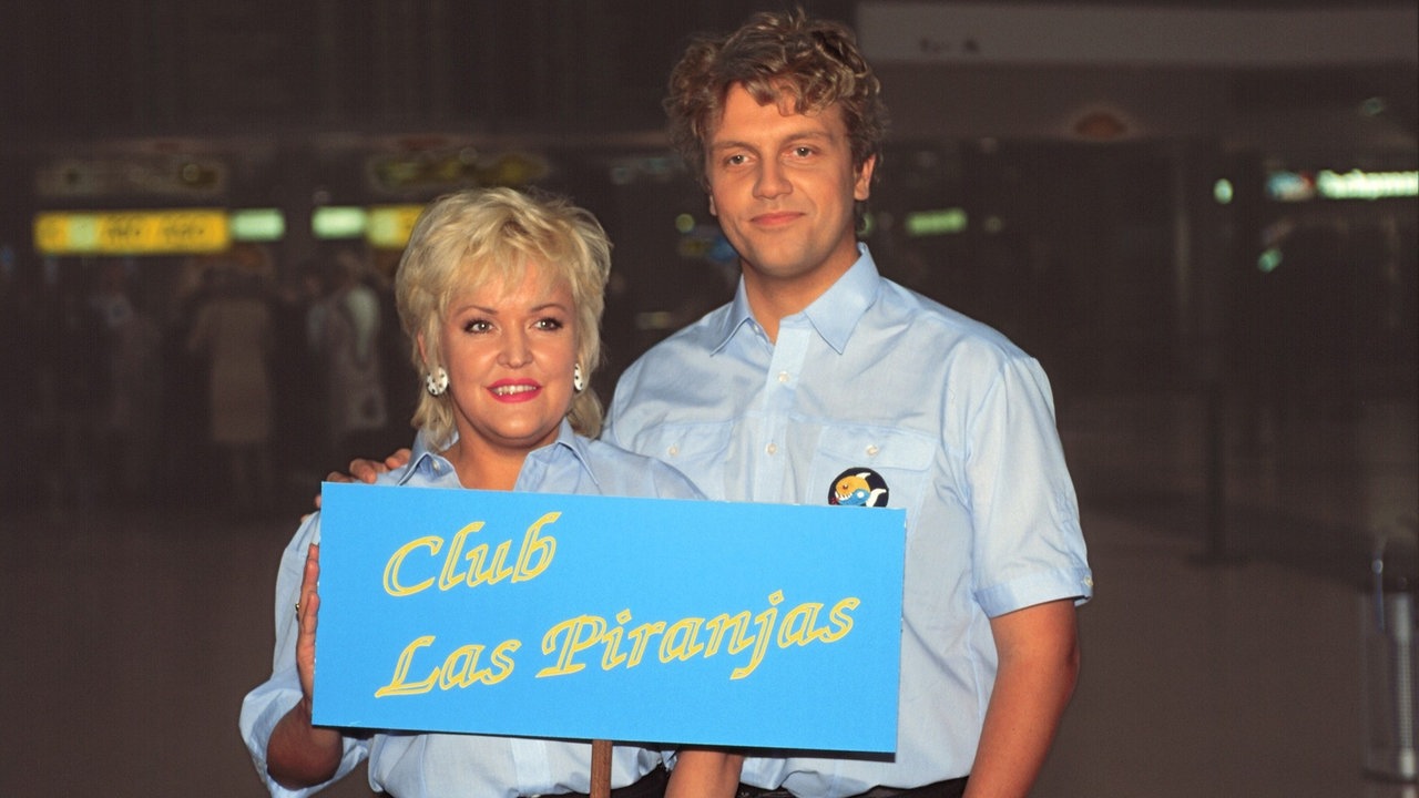 Angelika Milster und Hape Kerkeling zeigen ein Schild mit der Aufschrift "Club Las Piranjas"