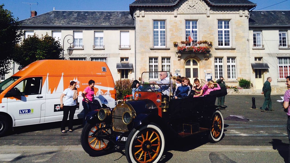 Zwei Overland-Oldtimer fahren auf einer Landstraße in der Eifel