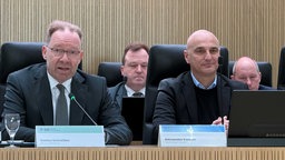 Stefan Schreiber von der IHK zu Dortmund und Oberbrügermeister Alexander Kalouti sitzen vor Mikrofonen nebeneinander.