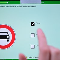 Eine Frau beantwortet eine Frage der theoretischen Prüfung des Führerscheins. 