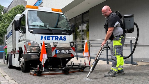 Reinigungskraft entfernt mit einer Dampflanze Kaugummireste 