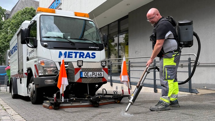 Reinigungskraft entfernt mit einer Dampflanze Kaugummireste 