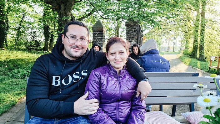 v. l. Florin Nistor und seine Frau Monica Sbârcea. Sie sitzen auf einer Parkbank.