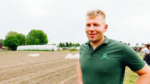 Landwirt Thorsten Westermann steht vor seinem Acker mit den Mietgärten.
