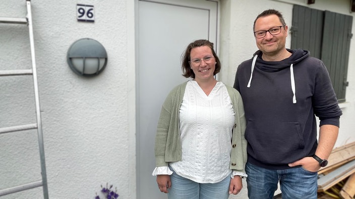 Wibke und Christian Gernert stehen vor ihrer Gartenlaube und lächeln in die Kamera.
