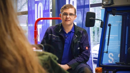 Landmaschinenmechatroniker Konstantin Winkler steht an einem Trecker