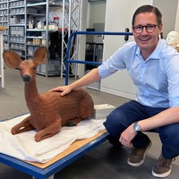Peter Schimmelpfennig hockt neben einem Reh-Dummy.