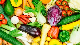 Verschiedenes Gemüse, wie Paprika, Möhren, Kohl und Zwiebeln liegt eng nebeneinander 