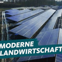 Ein unfertiger Solarpark darauf der Schriftzug "Moderne Landwirtschaft?!"