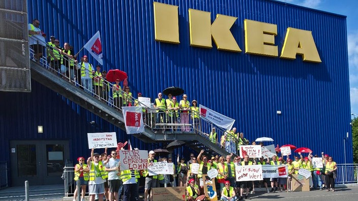 Jede Menge Mitarbeiter haben sich vor der Ikea Fassade zum Streiken versammelt.