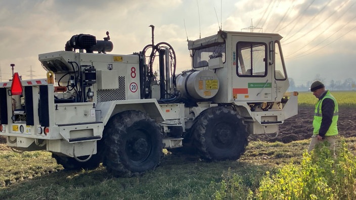 Ein Vibro-Truck steht auf einem Feld vor einem Sonnenuntergang