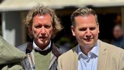 Investor Jochen Koenen (links) und Bürgermeister Rainer Benien (rechts). Koenen hat lange dunkle Haare und einen Bart. Benien hat kurze dunkle Haare und trägt ein beiges Sakko.