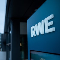 Ein weißer Schirftzug von RWE an der Firmenzentrale in Essen