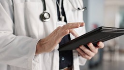 Arzt, der auf einem Tablet eine Röntgenaufnahme auswertet