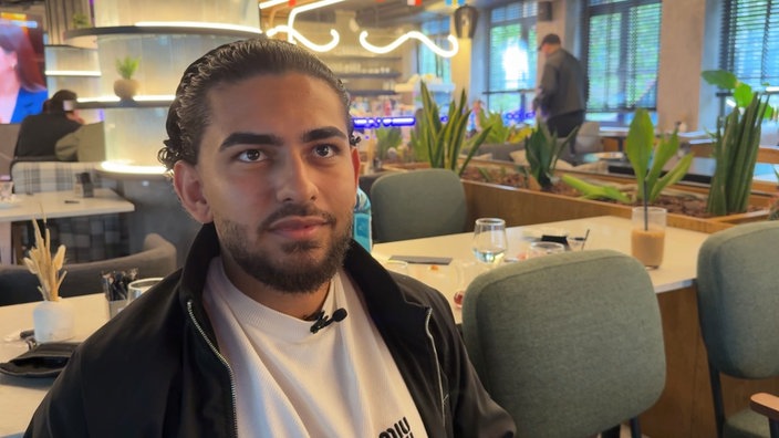 Osman Akin sitzt in einem Restaurant.