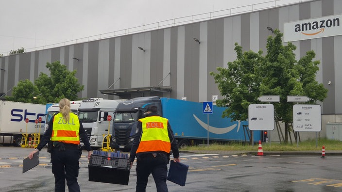 Zollbeamte gehen auf das Gelände eines Logistikunternehmens